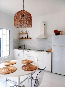 a kitchen with a white table and a white refrigerator at Dragon View - Oceanfront Apartment Faro de Sardina in Gáldar +16 photos