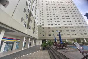 a large white building with chairs and umbrellas in a courtyard at Antareja LoftVilles By Reccoma in Dukuh +21 photos