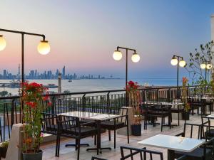 a restaurant with tables and chairs and a view of the water at ibis Kuwait Salmiya in Kuwait