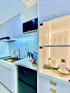 a kitchen with white cabinets and a sink at Luxe Living in Iloilo City