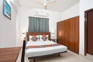 a bedroom with a bed and a wooden cabinet at Via Dream Nest in Hyderabad