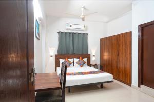 Un dormitorio con una cama y una mesa dentro. en FabExpress Dream Nest, en Hyderabad