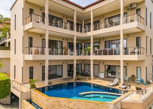 eine Außenansicht eines Gebäudes mit einem Swimmingpool in der Unterkunft Panoramic Sea View Chaweng Hill Modern Apartment in Ban Ko Khwan