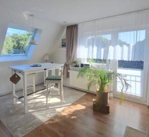a living room with a white desk and a table at Kleine Auszeit Pellworm in Pellworm