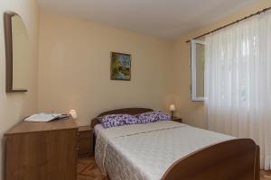 - une chambre avec un lit, un bureau et une fenêtre dans l'établissement Apartmani Premeru, à Makarska