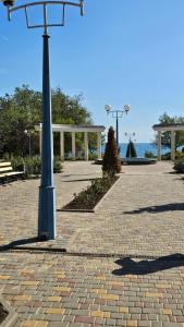 a street light in a park with a bench at Апартаменты у моря м Южне in Sychavka