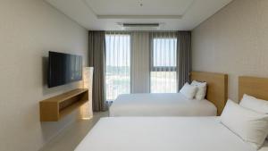 a hotel room with two beds and a flat screen tv at Centum Mark Kimstay Yangyang in Yangyang +113 photos