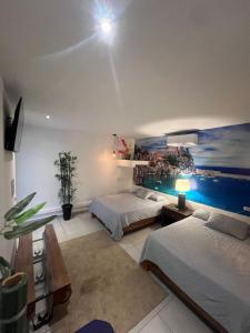 a bedroom with two beds and a painting on the wall at VILLA NAPOLI in Santa Ana +124 photos