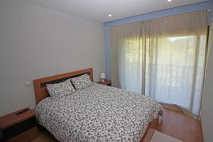Un dormitorio con una cama y una ventana grande. en Encostas da Torre, en Terras de Bouro 72 fotos más