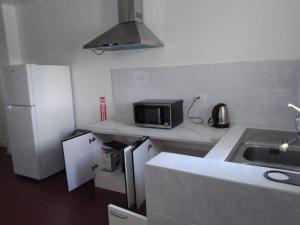 a small kitchen with a sink and a microwave at SUNSHINE HOTel in Tinian