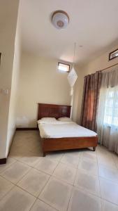 a bedroom with a bed in the corner of a room at Karibu motel mbale in Mbale
