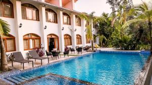 a hotel with a swimming pool in front of a building at Aeraki palms in Bordi