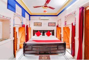 Jodhpur Heritage Haveli Guest House في جودبور: غرفة نوم بسرير ومخدات حمراء +98 صورة