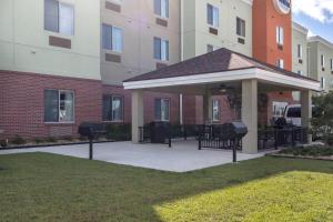 a gazebo with tables and chairs in front of a building at Suburban Studios Donaldsonville - Gonzales in Donaldsonville
