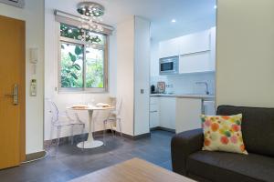 ein Wohnzimmer mit Couch und Tisch und eine Küche in der Unterkunft Suites Garden Loft Miro in Las Palmas de Gran Canaria