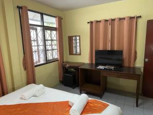 Zimmer mit einem Schreibtisch, einem Computer und einem Bett in der Unterkunft Kata Leaf Resort Phuket - in Kata Beach