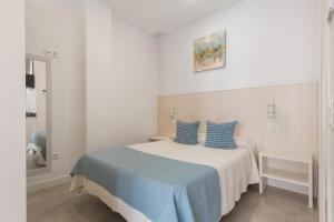 a bedroom with a bed with blue pillows on it at Modern Loft in Málaga in Málaga