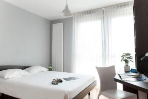 a bedroom with a bed and a desk with a laptop at Comfort Aparthotel Besancon Hauts du Chazal in Besançon