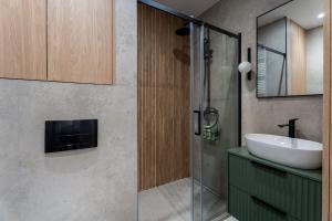 a bathroom with a sink and a glass shower at Przytulne Studio Sikorskiego Balkon i Parking by Noclegi Renters in Kielce