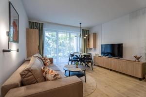 a living room with a couch and a dining room at Przytulne Studio Sikorskiego Balkon i Parking by Noclegi Renters in Kielce