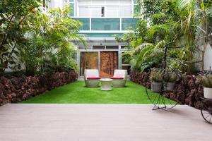 einen Innenhof mit Stühlen und Pflanzen in einem Gebäude in der Unterkunft Suites Garden Loft Miro in Las Palmas de Gran Canaria