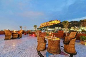 Jodhpur Heritage Haveli Guest House في جودبور: صف من الكراسي والطاولات على السطح