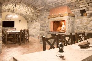 a stone fireplace in a restaurant with a table and chairs at Casa Rural Pueyo in El Pueyo de Araguás