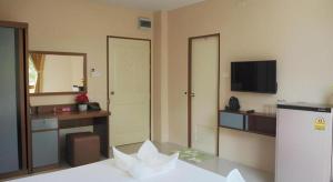 a room with a bed and a tv and a mirror at Regent Room Hotel in Suratthani
