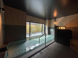 a swimming pool in a building with a window at Hotel Route Inn Kyoto Kumiyama in Kyoto