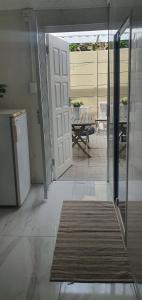 Una puerta a un patio con una alfombra delante. en Sufi'Sawd Guest Rooms Muizenberg, en Muizenberg 31 fotos más