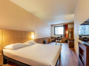 a bedroom with a large bed and a living room at Ibis Bilbao Centro in Bilbao +105 photos