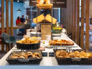 a table with baskets of bread and pastries on it at Ibis Bilbao Centro in Bilbao