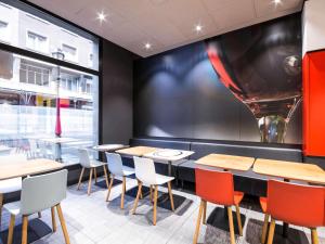 a restaurant with tables and chairs and a large window at Ibis Bilbao Centro in Bilbao