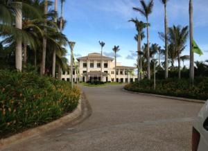 a large white house with palm trees and a driveway at La Isla Gran Cayman 904 in Acapulco