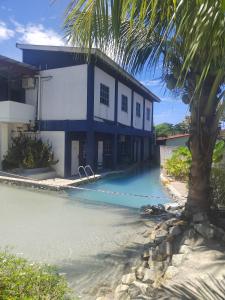 a building with a swimming pool next to a house at Nu Melati Hotel in Pantai Cenang