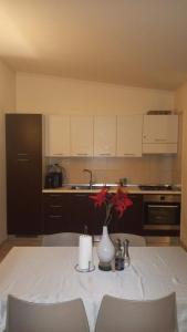 a kitchen with a table with a vase with flowers on it at Tropical Resort Pool View - Three Bedroom in Santa Maria