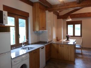 a kitchen with a sink and a dishwasher at Posada El Hoyal in Pesaguero-La Parte