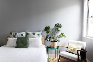 a bedroom with a bed and a chair and a plant at Solara in Kingscliff +22 photos