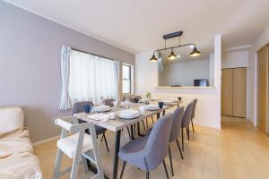 ein Esszimmer mit einem langen Tisch und Stühlen in der Unterkunft Nagoya15min 6 beds Free Parking 3BR 13guests 100sqm in Nagoya + 40 Fotos