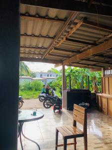 a patio with a table and a chair and a motorcycle at Lanta Vacation House in Ko Lanta Yai