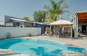 a swimming pool in a yard with a house at NJ SKY GUESTHOUSE & BOUTIQUE windhoek in Windhoek