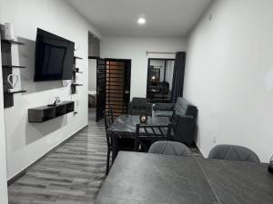 a living room with a television and a table and chairs at Casa Andares in Colima