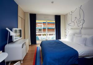 a bedroom with a bed and a tv and a window at Hotel Victoria in Roquebrune-Cap-Martin