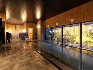 a large swimming pool in a building with a swimming pool at Hotel Route Inn Grand Moriya Ekimae in Moriya