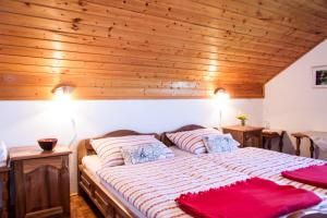 a large bed in a room with wooden ceilings at B&B Villa Nena in Plitvica Selo