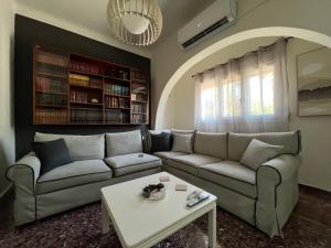 a living room with a couch and a table at The Book Shelter in Chalkida