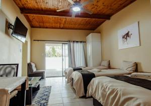 a hotel room with two beds and a ceiling fan at NJ SKY GUESTHOUSE & BOUTIQUE windhoek in Windhoek