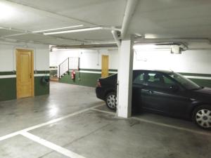 
a car parked in a garage next to a building at Posada Don Jaime in San Lorenzo de El Escorial
