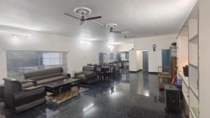Una sala de estar con sofás y un ventilador de techo. en RoHans FarmStay and Events, en Wangāpalli