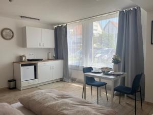 a room with a kitchen and a table with chairs at Lunetha Homes in Laudenbach